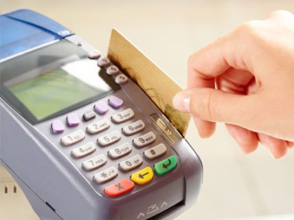 Credit card being swiped for dental payment at North County Cosmetic and Implant Dentistry in Vista, CA, financial policy